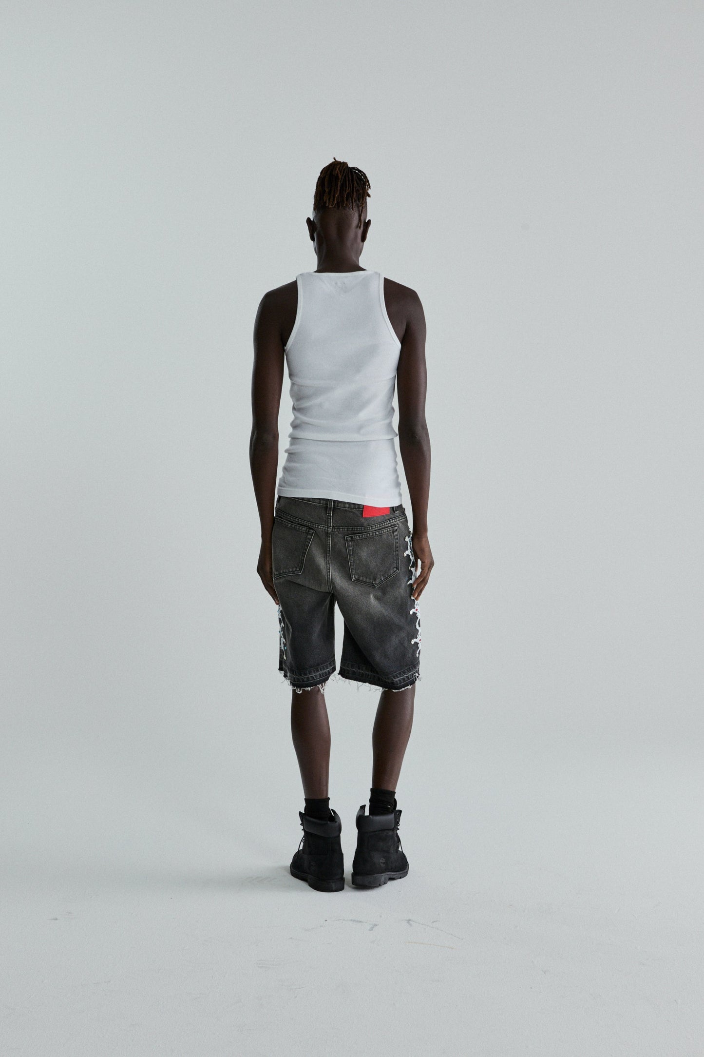 BLACK WASH WEB STONE DENIM SHORTS ON MODEL