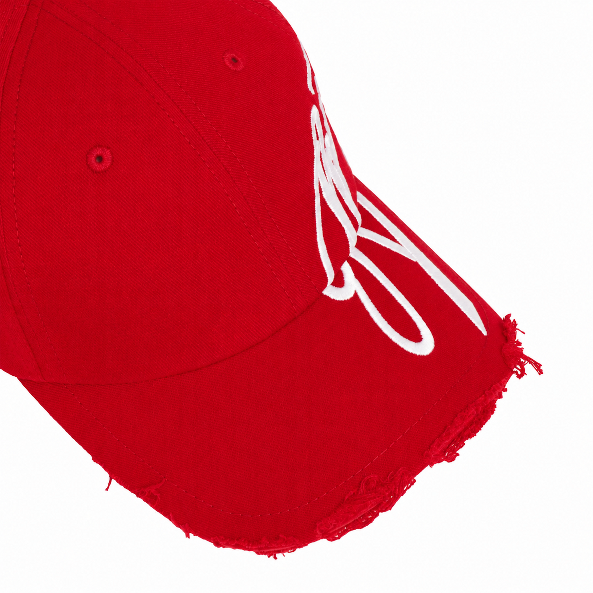 Bright red baseball cap with white cursive graphic embroidery and distressed detailing along the curved brim edge.