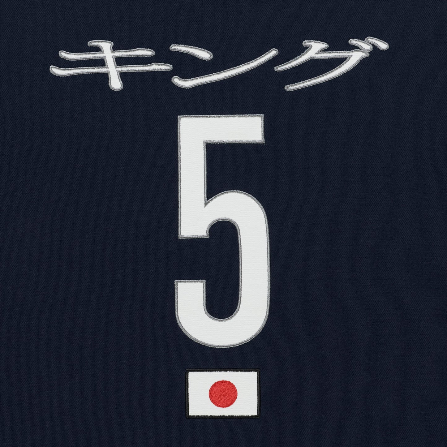 Navy polo with embroidered white Japanese text, large white number 5, and a small Japanese flag patch.