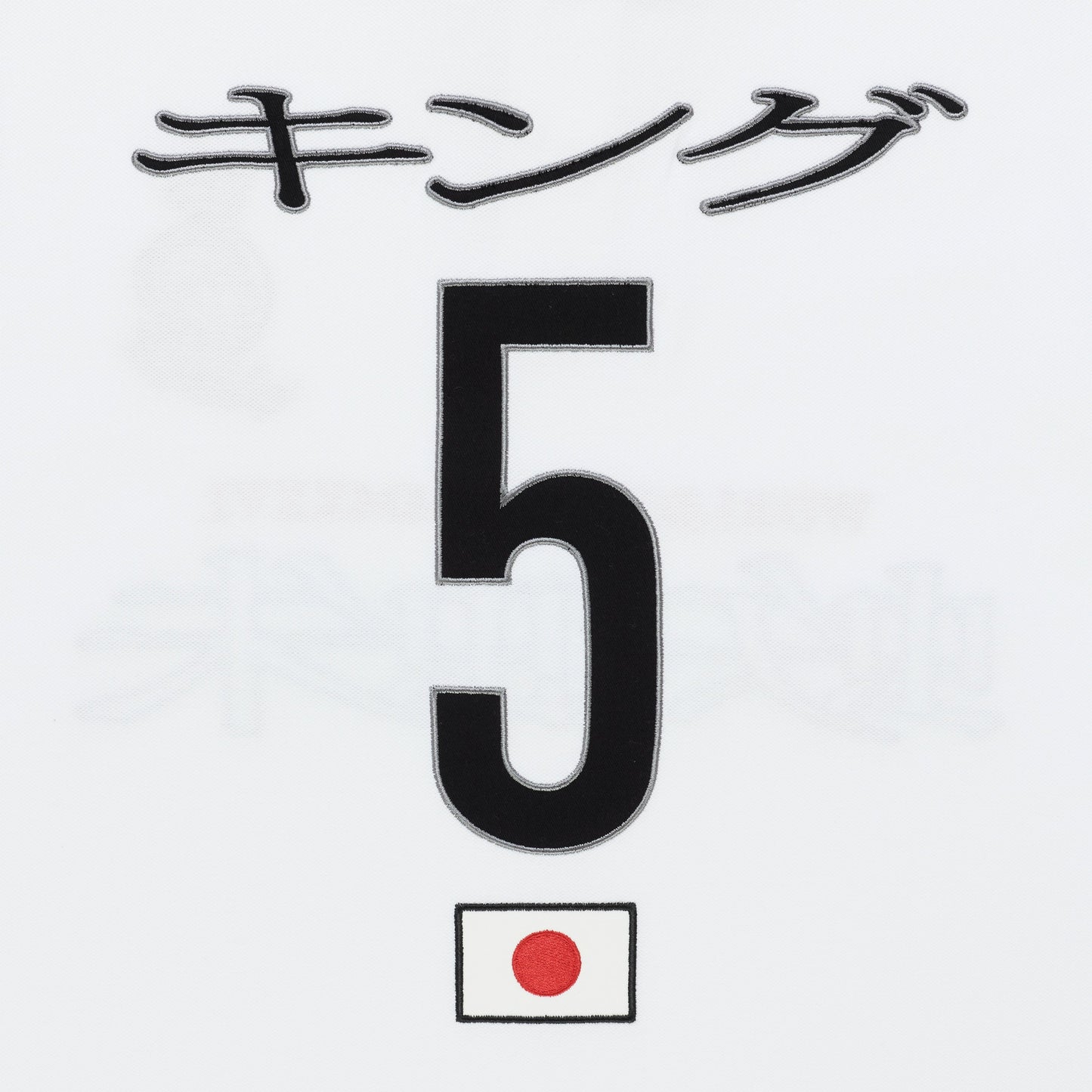 White polo shirt detail with black Japanese text "キング", large black number 5, and a small Japanese flag.