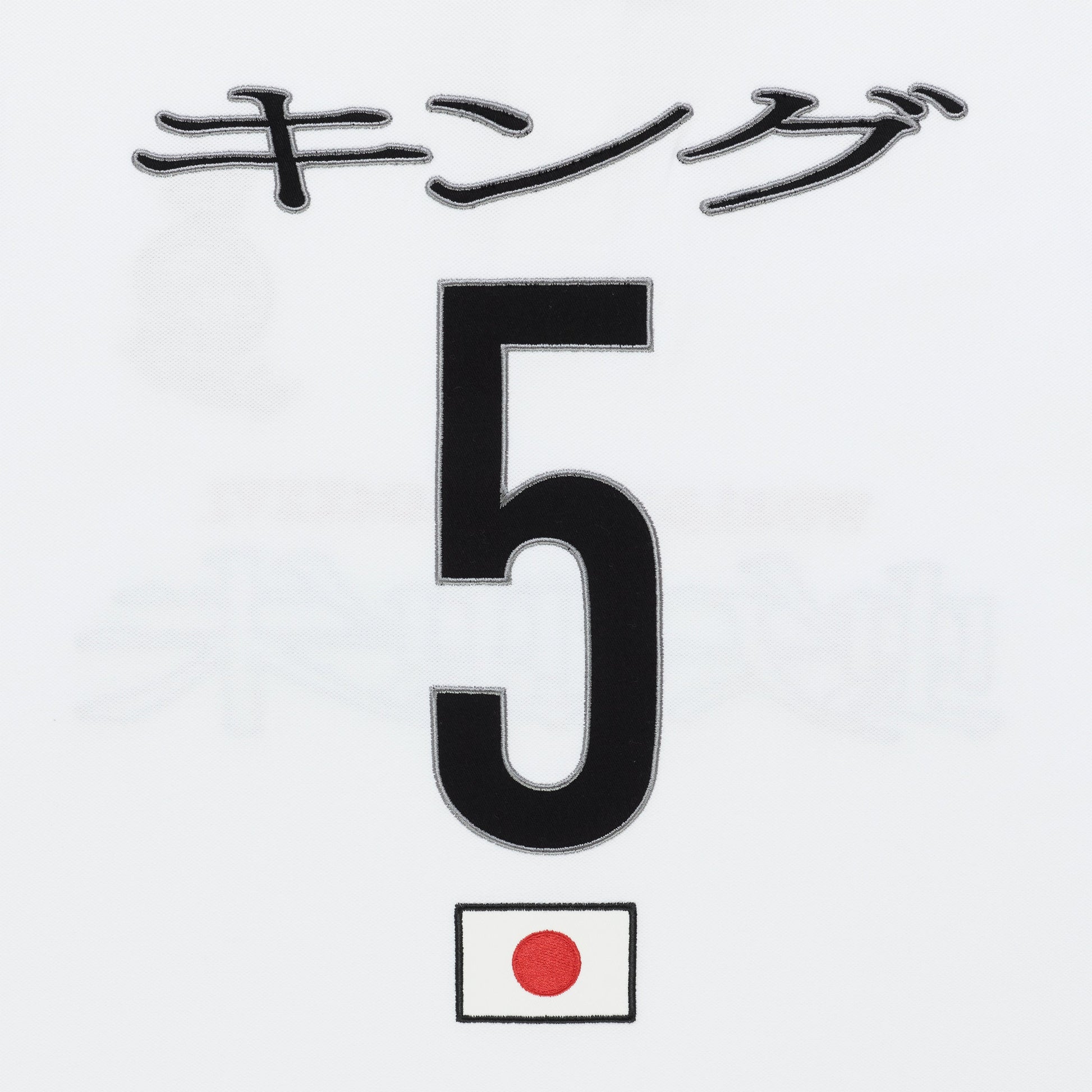White polo shirt detail with black Japanese text "キング", large black number 5, and a small Japanese flag.