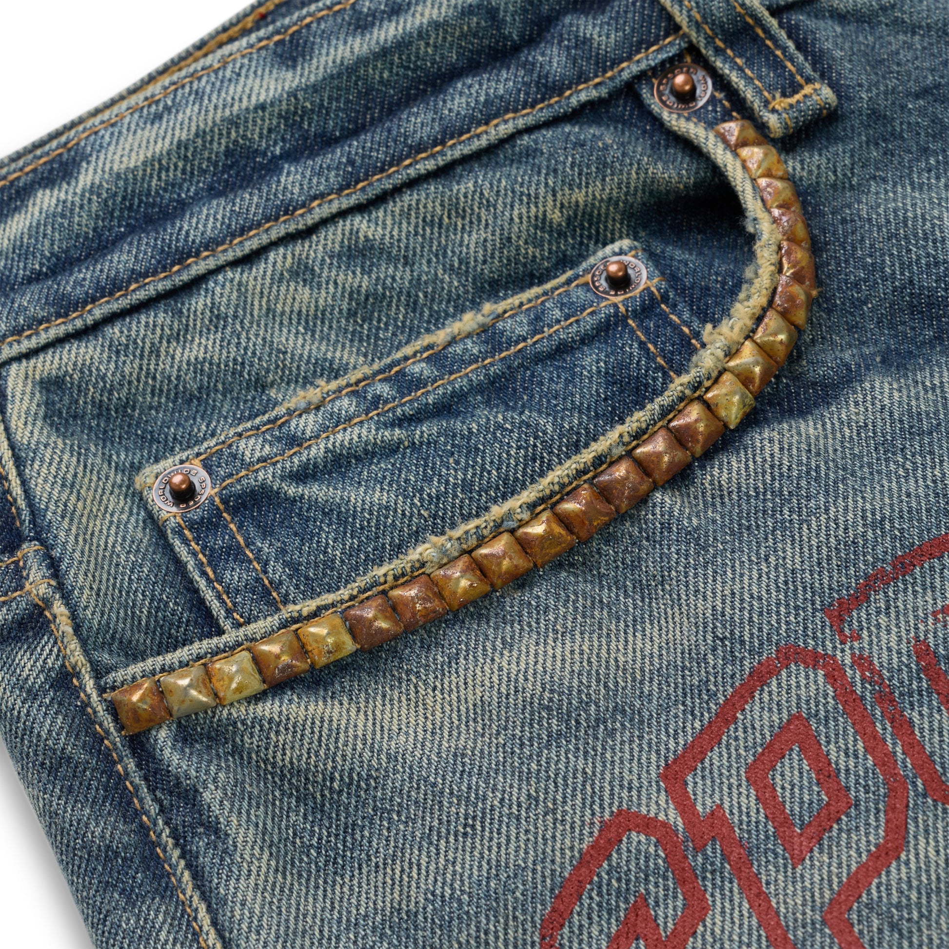 Washed blue denim jeans with a studded front pocket and a red graphic print.