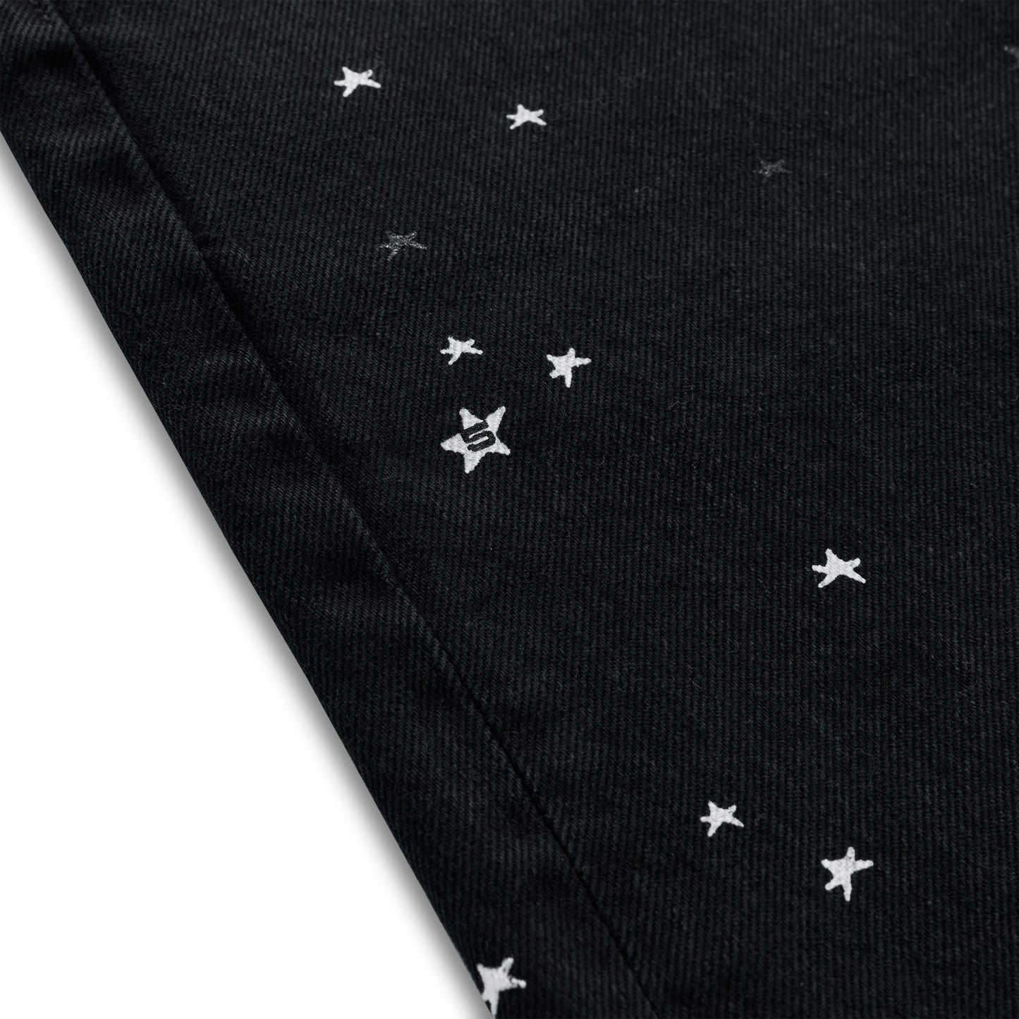 Black denim jean short with white embroidered stars and an "S" logo.