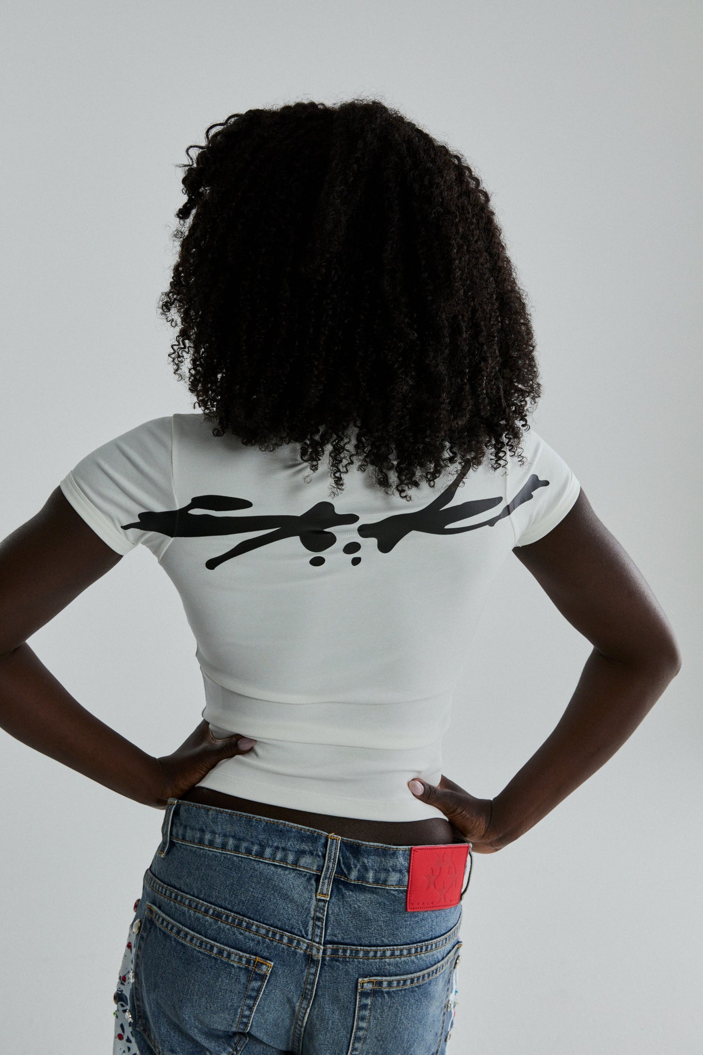 WHITE TM BABY TEE ON MODEL