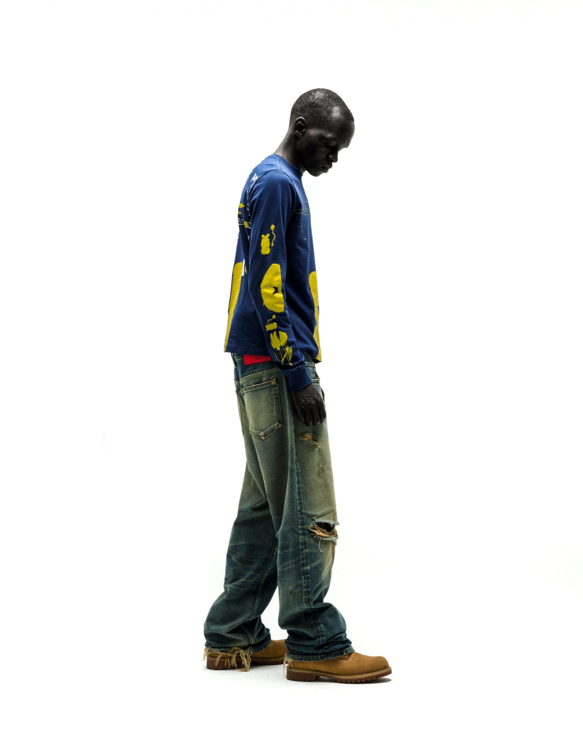 Model wearing a navy blue 100% cotton X-RAY LONGSLEEVE with yellow graphic print on front, back, and sleeves.