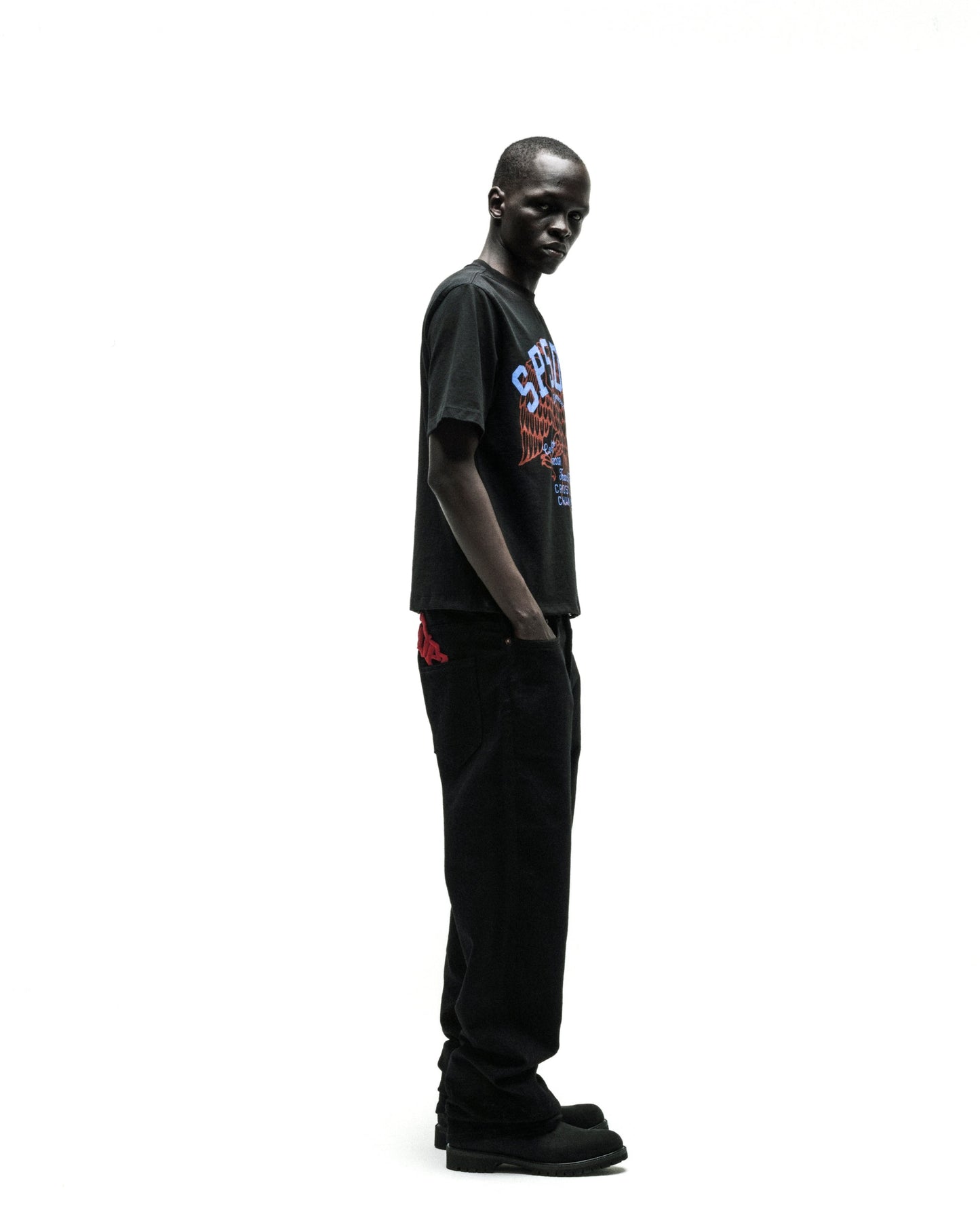Black Champions League tee with a colorful graphic, paired with black jeans and shoes.