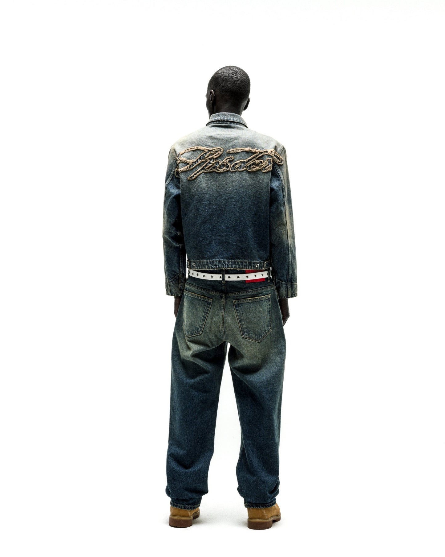 Distressed blue denim work jacket with "SCRIPT" embroidery on back, paired with matching jeans.