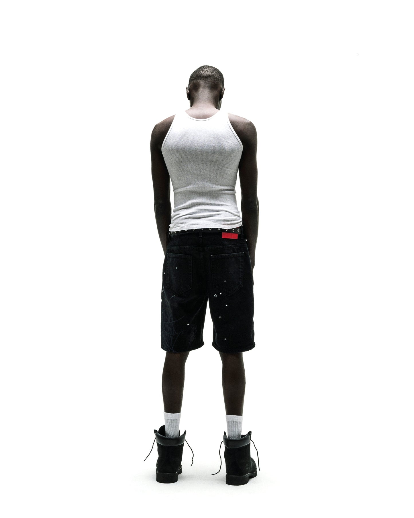 Black denim Heavy Web Jean Short with silver studs, red tag, and black boots.