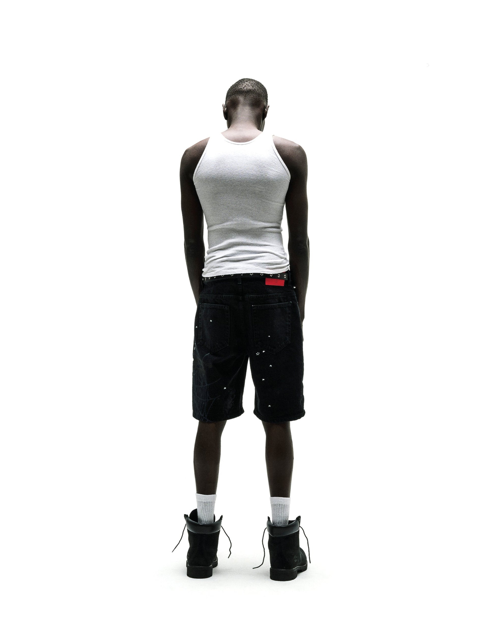 Black denim Heavy Web Jean Short with silver studs, red tag, and black boots.